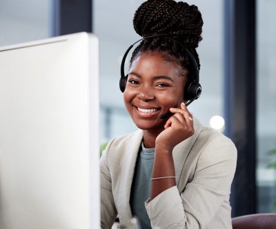 Portrait of a young call centre agent working on a computer in an office.